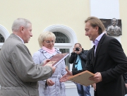 Председатель Думы района Владимир Алексеев дарит Евгению Антонову книгу о Боровичах.